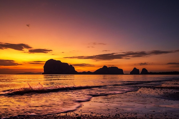 Foto een zonsondergang op het strand met de zee op de achtergrond