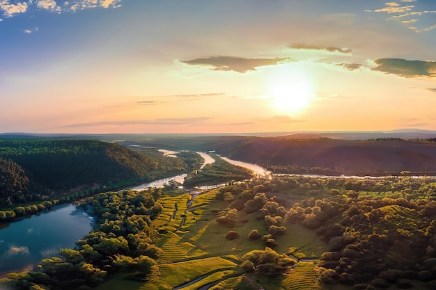 Een zonsondergang over de rivier en de bergen