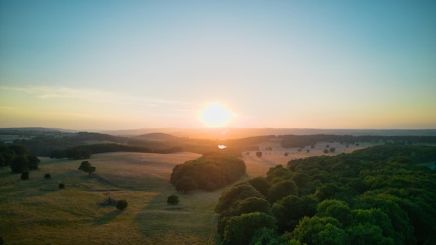 Een zonsondergang over een veld met de zon achter zich.