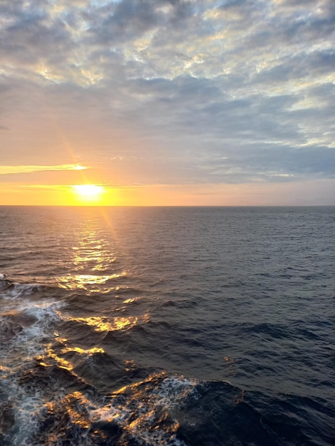 Een zonsondergang over het water met daarachter de ondergaande zon