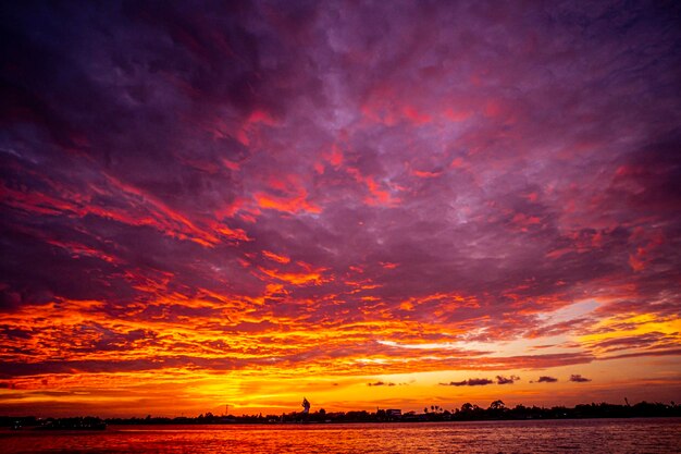 Een zonsondergang over het water met een stad op de achtergrond