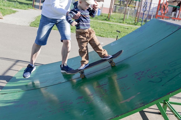 Een zorgzame en liefhebbende vader leert zijn driejarige zoon skateboarden