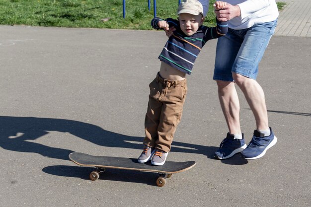 Een zorgzame en liefhebbende vader leert zijn driejarige zoon skateboarden