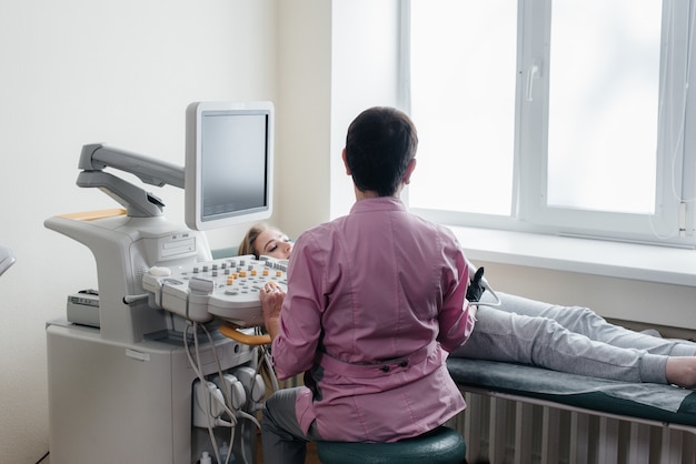 Een zwanger meisje krijgt in de kliniek een echo van haar buik. Geneeskundig onderzoek