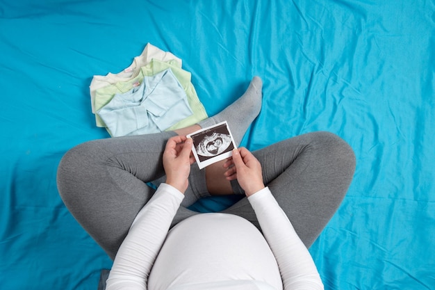 Een zwanger meisje verzamelt kinderspullen Voorbereidingen voor een reis naar de kraamkliniek Wachten op de geboorte van een kind