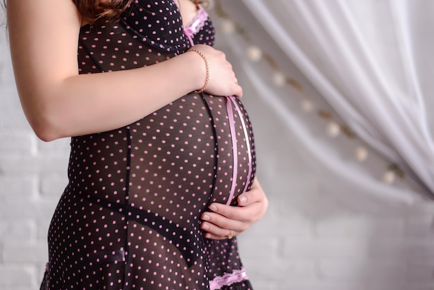 Een zwangere vrouw De vrouwenhanden zijn op haar buik