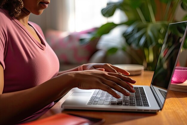 Een zwangere vrouw die een laptop op een bureau gebruikt