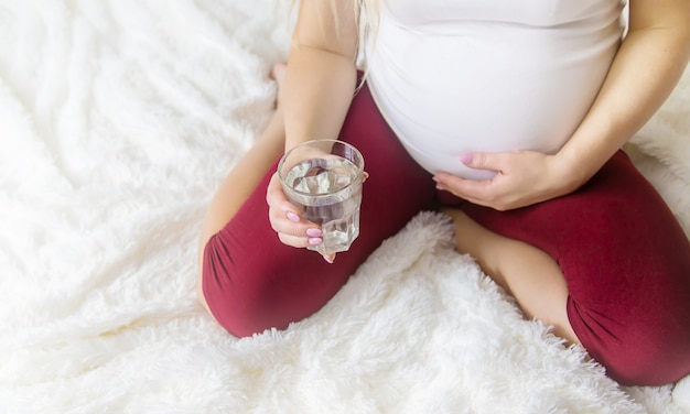 Een zwangere vrouw drinkt water. Selectieve aandacht.