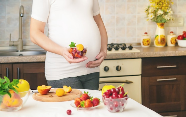 Een zwangere vrouw eet fruit