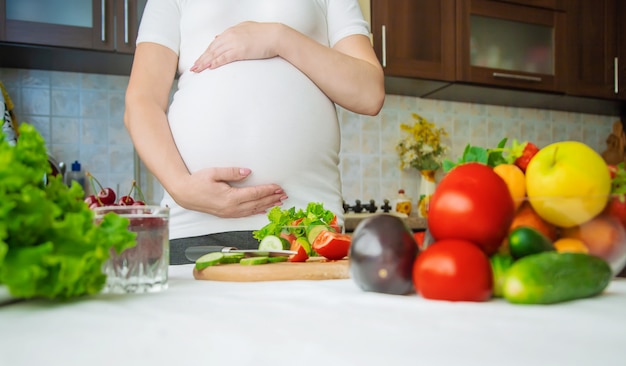 Een zwangere vrouw eet groenten en fruit