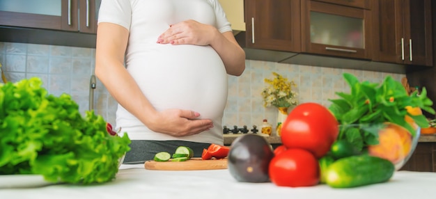 Een zwangere vrouw eet groenten en fruit