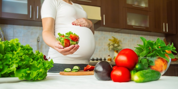 Een zwangere vrouw eet groenten en fruit