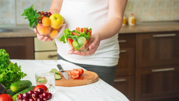 Een zwangere vrouw eet groenten en fruit