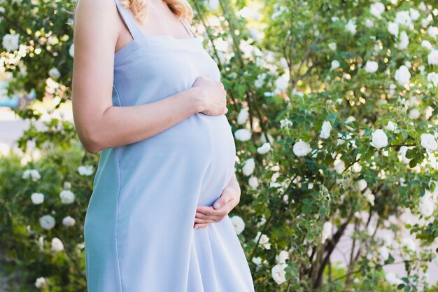 Een zwangere vrouw in een blauwe jurk