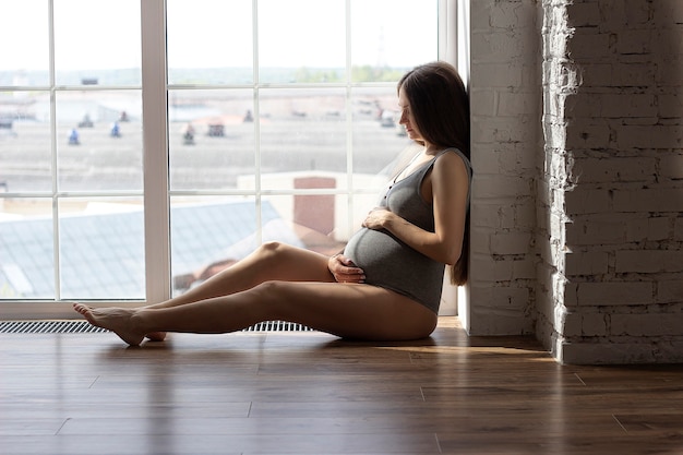 Een zwangere vrouw streelt zachtjes haar buik terwijl ze wacht op de geboorte van een kind