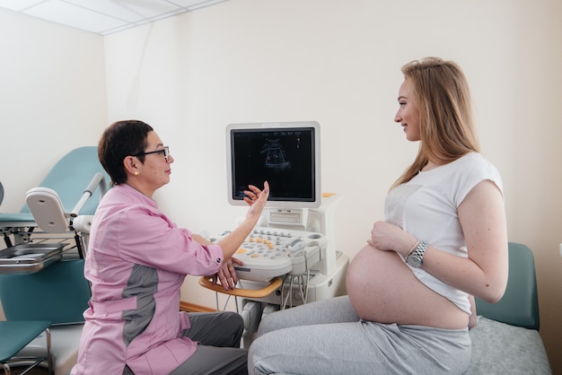 Een zwangere vrouw wordt door een arts geadviseerd na een echo in de kliniek. Geneeskundig onderzoek