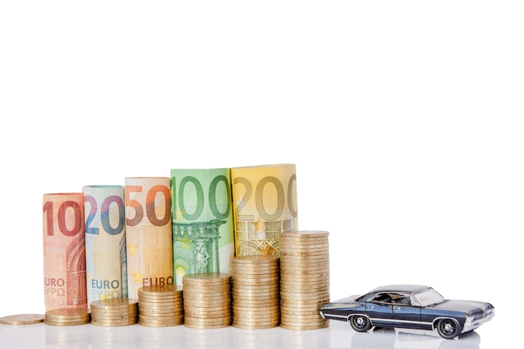 Foto een zwart model van een auto en tien, twintig, vijftig, honderd, tweehonderd en munten euro opgerolde biljetten bankbiljetten op wit oppervlak. histogram van de euro. concept van valutagroei, besparingen.