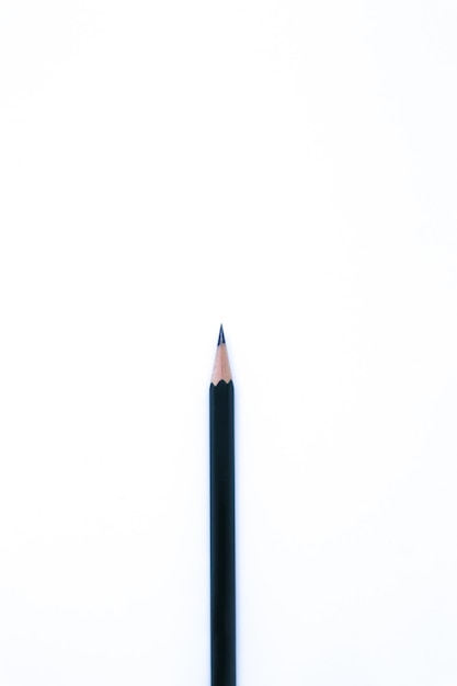 Een zwart potlood met platliggende opname op de witte achtergrond, portretmodus en minimalistisch