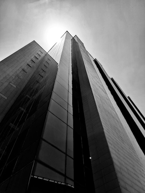 Een zwart-witfoto van een hoog gebouw waarop de zon schijnt.