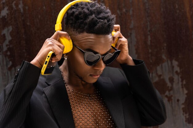 Een zwarte etnische man die naar muziek luistert, een draadloze gele koptelefoon met een hartzonnebril