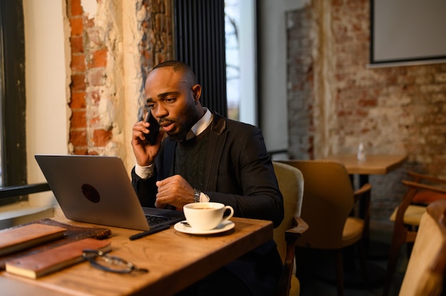 Een zwarte man werkt op een laptop close-up van zijn gezichtsvideoconferenties