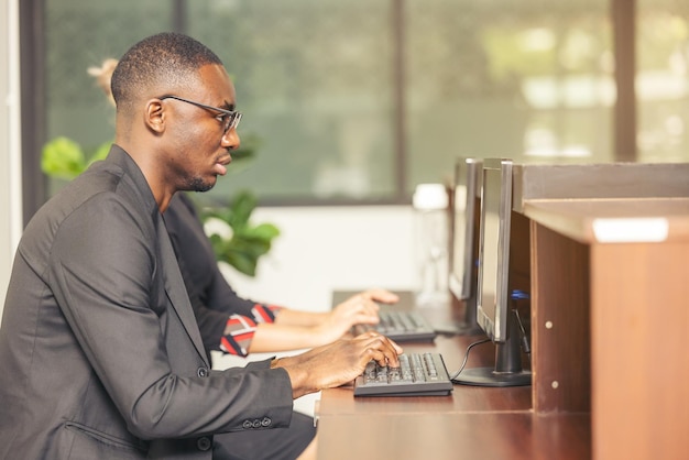 Een zwarte man werkt op een tabletcomputer in de hotellobby