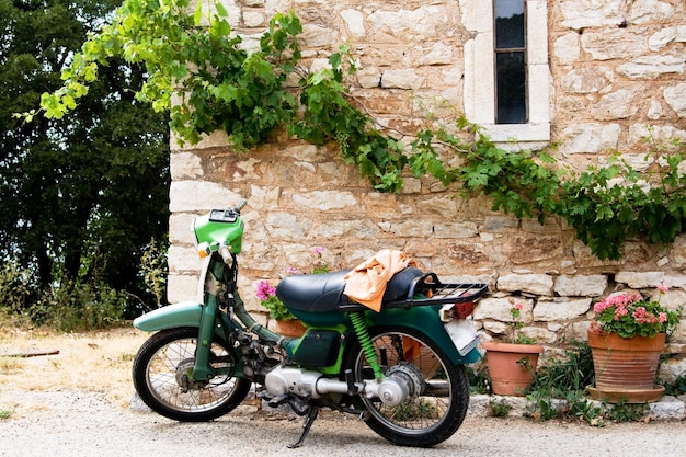 Foto een zwarte motorfiets staat bij zonnig weer in de buurt van een stenen muur in griekenland