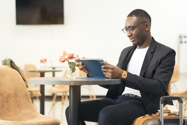 Een zwarte zakenman werkt op zijn laptop in een café