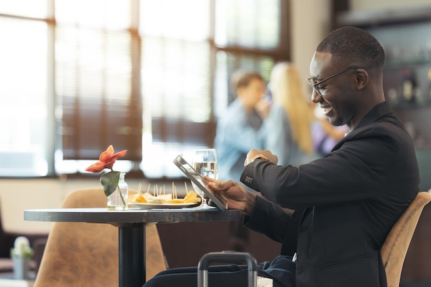 Een zwarte zakenman werkt op zijn laptop in een café