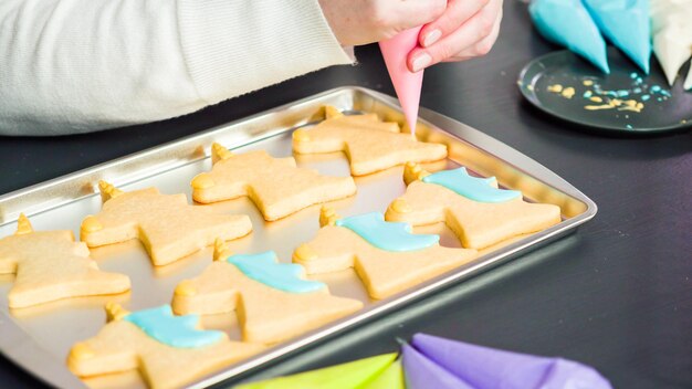 Eenhoornsuikerkoekjes versieren met meerkleurige royal icing.