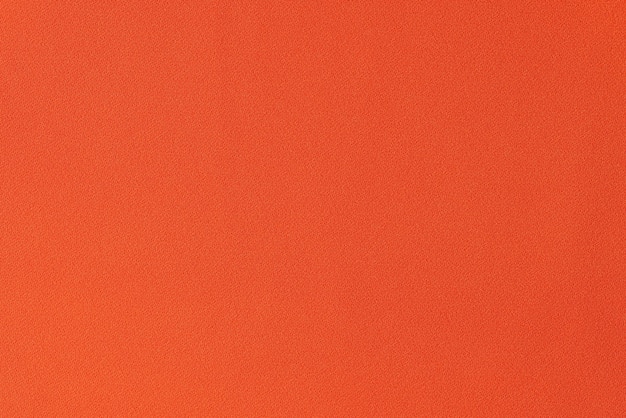 Eenkleurige feloranje stof als achtergrond close-up van oranje textiel