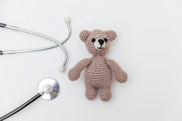 Eenvoudig minimaal ontwerp speelgoed beer en geneeskunde apparatuur stethoscoop geïsoleerd