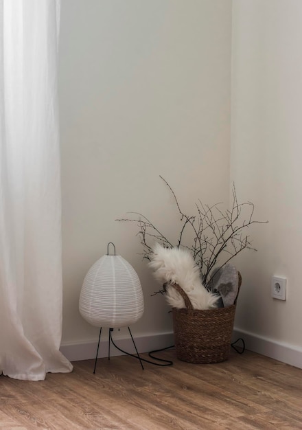 Eenvoudig minimalisme stijl interieur decor een mand met droge takken een papieren lamp op de vloer in de hoek van de woonkamer