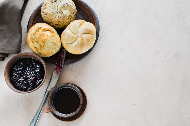 Eenvoudig ontbijt: koffie americano, verse broodjes en jam.