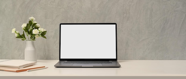 Eenvoudige minimale werkruimte met laptop leeg scherm mockup, accessoires en kopieerruimte over loft muur.