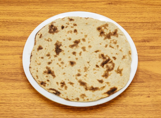 Eenvoudige tandoori roti geserveerd in plaat geïsoleerd op tafelblad weergave van Indiase en Pakistaanse gekruide gerechten