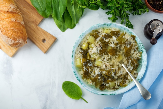 Eenvoudige vegetarische soep gemaakt van zuring, aardappelen en losgeklopte eieren op een lichte ondergrond