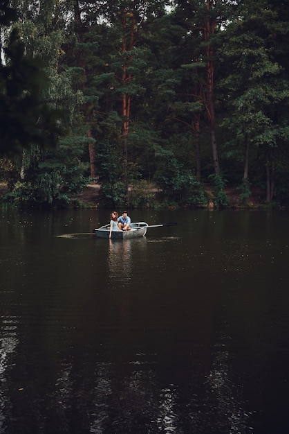 Eenvoudige vreugde van liefhebben. Mooie jonge paar genieten van romantische date tijdens het roeien van een boot