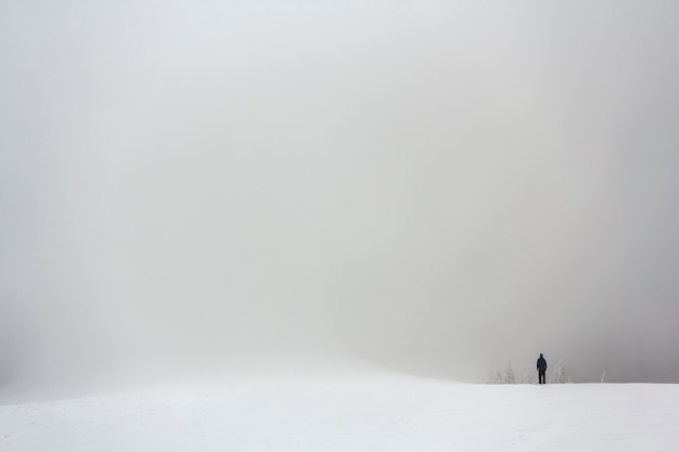 Eenzaam figuur van een man die in de winter buiten staat