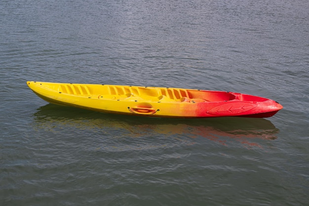 Eenzaam geel en rood zitten op de bovenste kajak in het midden van kalm en kalm zeewater