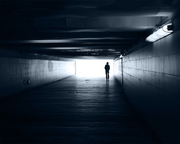 Eenzaam silhouet in een metrotunnel tegen het licht