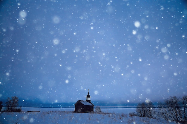 eenzame houten kerk in het veld / concept geloof, god, eenzaamheid, architectuur in het winterlandschap