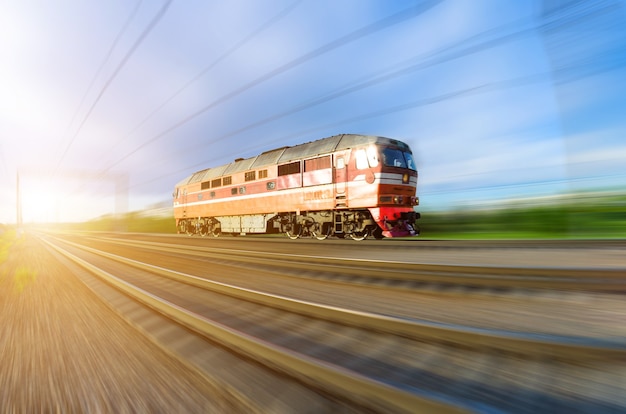 Eenzame locomotief snelt met de trein bij zonsondergang.