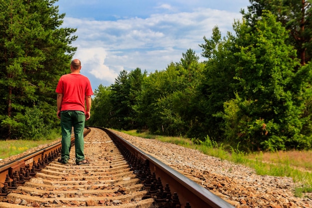Eenzame man die op een spoorlijn loopt