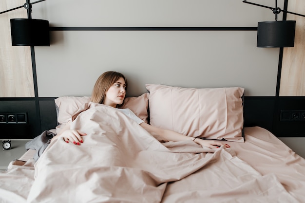 Eenzame vrouw in bed wakker in de ochtend alleen thuis