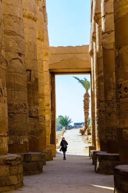 Eenzame vrouwenfiguur tussen de zuilen in de grote zuilenhal van de Karnak-tempel