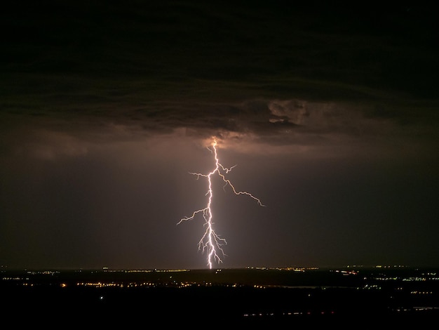 Eerie scenery of lightning strike hitting a town in a dark night