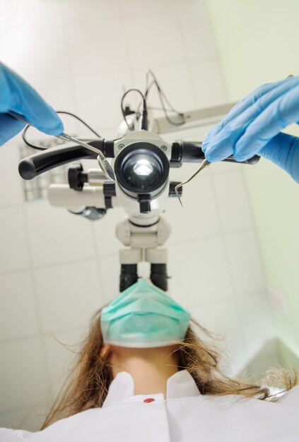 Eerste persoonsmening over vrouwelijke tandarts die microscoop gebruikt