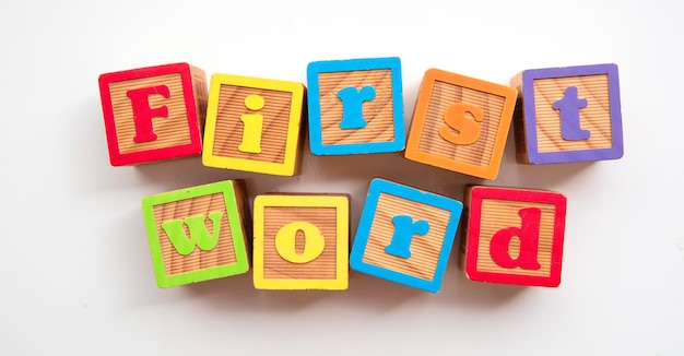 Eerste woord woord gemaakt van kleurrijke houten ontwikkelingsblokken voor baby's