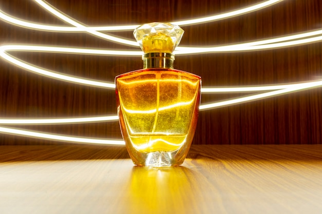 Eersteklas parfumfles geïsoleerd op houten achtergrond met licht trail effect